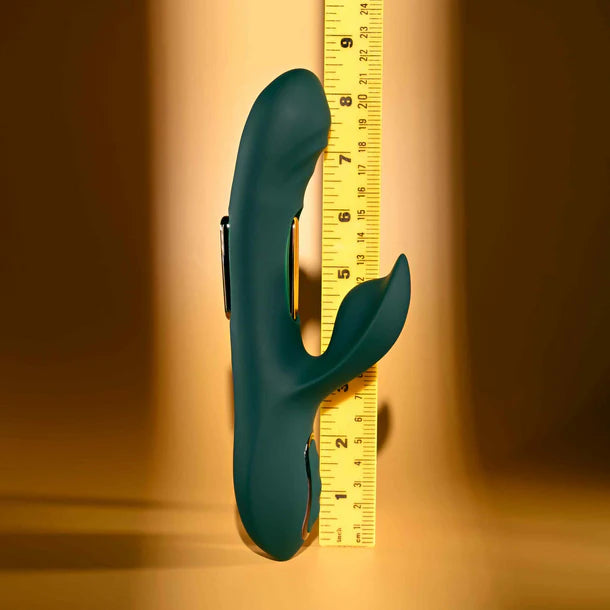 Green vibrator with a ruler for scale on a brown background