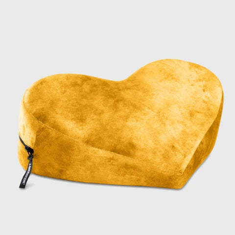 Heart-shaped yellow pillow with a zipper on a light gray background