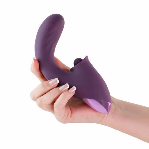 Hand holding a purple silicone purple vibrator on a white background