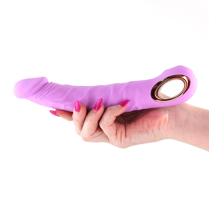 Hand holding a Pink and rose gold Inya Flex vibrator against a white background