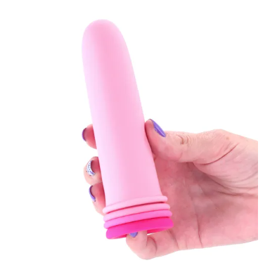 Hand holding a pink dilator set against a white background