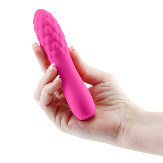 pink vibrator with smooth bottom and ridged top being held in hand