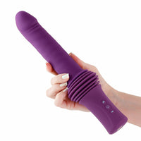 purple inya super stroker thrusting vibrator held in a hand on a white background