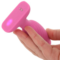 Pink swirl anal plug held in a hand with a white background