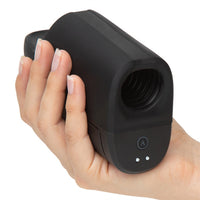 Hand holding a black ion 2 masturbator against a white background