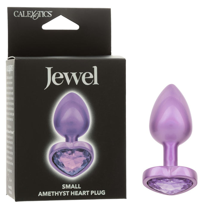 small anal plug with heart shaped bottom with purple gem beside box packaging