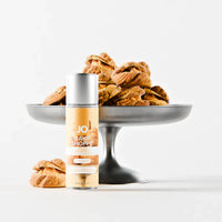 Bottle of JO Bake Shoppe orange creampuff lube with pastries on a white background