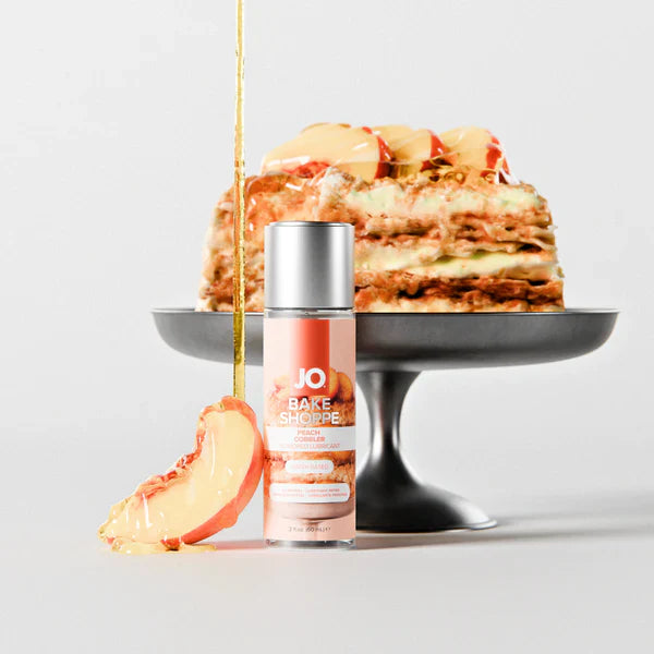 jo peach cobbler lubricant product with a cake and apple slice on a light gray background