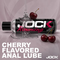 Jock Cherry Flavored Anal Lube with lub pouring and cherries on a light purple background
