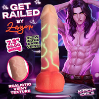 Promotional graphic for a novelty dildo with a realistic flesh-toned shaft and glowing green vein-like lines, plus an orange bulb base. Large text reads 'GET RAILED BY Zayon,' '7.