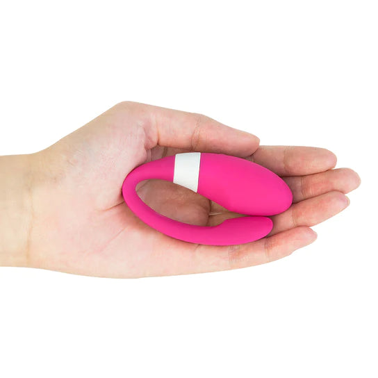 a hand holding a pink and white c-shaped vibrator