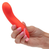 Hand holding a red silicone kroma turbo curve virbator against a white background