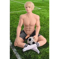 blonde sitting on grass with soccer ball