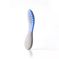 A curved personal massager with a white body and glowing blue LED light strip, standing upright on a white background.