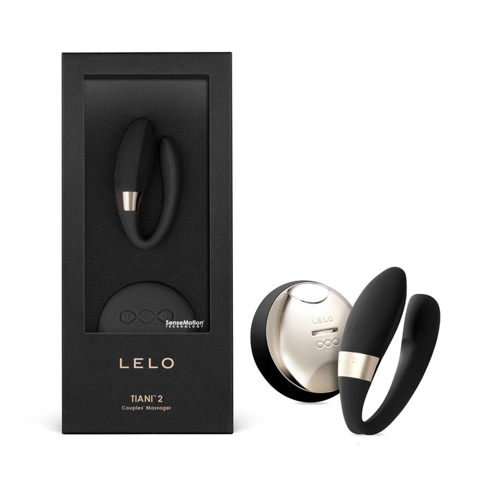 black c curved vibrator with remote beside box packaging