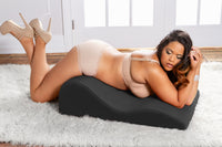 woman laying on a black wedge on the floor