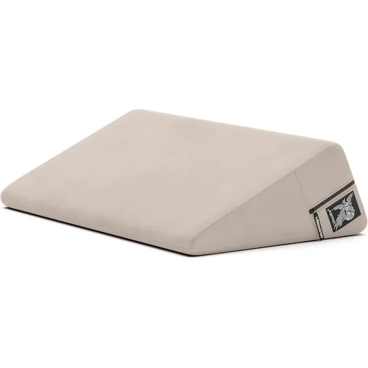 cream wedge pillow with a liberator logo on a white background