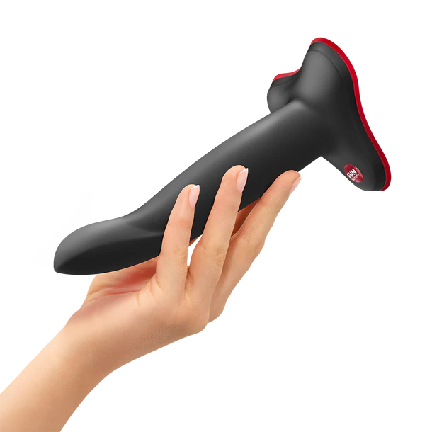 Black and red limba flex m dildo held by a hand on a white background