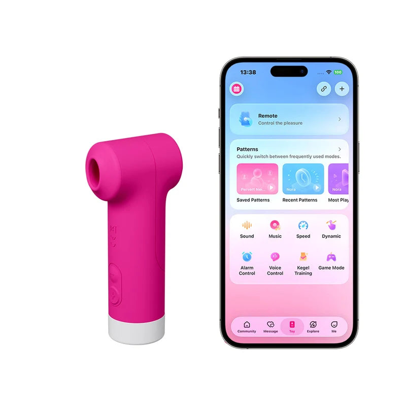 A bright pink handheld personal massager with a white base stands next to a smartphone displaying a companion app interface. The phone screen shows options like remote control, patterns, sound, music, speed, dynamic, alarm control, voice control, target training, and game mode.