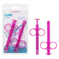 a pink lube dispensing syringe next to its additional tube, shown next to its plastic packaging