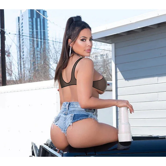 luna star in a bikini top and denim shorts sitting on a car with a cityscape background