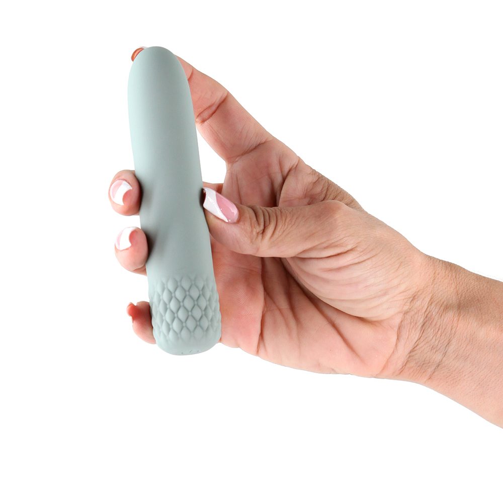 Hand holding a sage color vibrator against a white background
