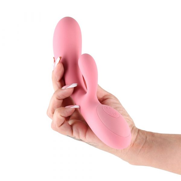 Pink silicone vibrator held in a hand against a white background