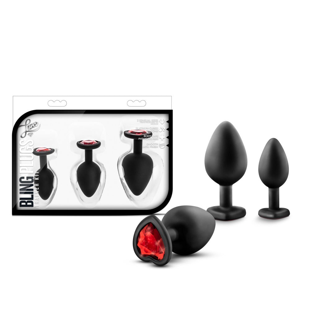 3 black anal plugs with red heart gem bottoms beside box package