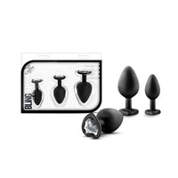 3 black anal plugs with clear heart gem bottoms beside box package