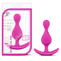 A bright pink silicone anal plug shown next to its retail packaging on a plain white background. The box is white with bold pink text and graphics, and the product itself is displayed standing upright.