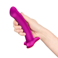 Hand holding a purple and red magnum g spot dildo against a white background
