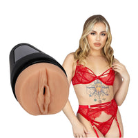 adult star anna claire clouds wearing red ra, panty and garter set, standing beside realistic molded vagina masturbator