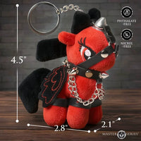 Red plush keychain with black accents and measurements on a wooden surface.