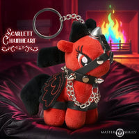 Scarlett Chainheart plush keychain from Master of Series, featuring a red and black devil-themed pony with a metal key ring, wearing a spiked collar and harness, set against a dark red draped fabric with a blurred fireplace background.