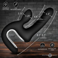 Black silicone dual-stimulation vibrator with dimension callouts showing fully extended lengths, set against a dark brick wall and wooden surface background.