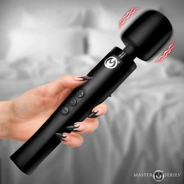 Black handheld massager being held by a hand with a blurred background