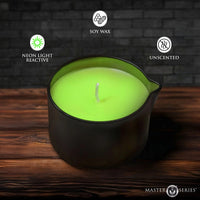 Green candle in a black holder on a wooden surface with soy wax, neon light reactive, and unscented features indicated.