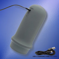 grey masturbator with USB-C charging cord on a blue background