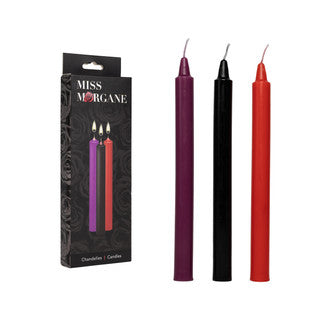 Set of three candles in purple, black, and red with packaging labeled 'Miss Morgane' on a white background.