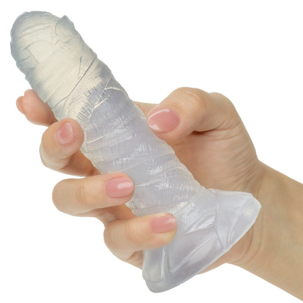 Hand holding a clear mummy wrapped dildo on a white background