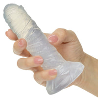 Hand holding a clear mummy wrapped dildo on a white background