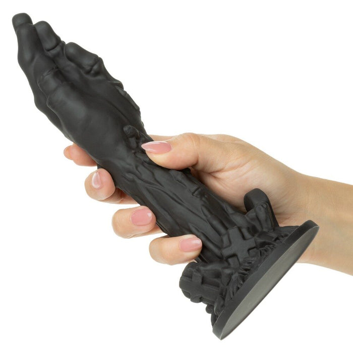 Hand holding a black monster zombie dong with intricate design on a white background