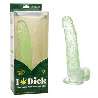 a clear penis shaped dildo with confetti weed inside, balls and a suction cup. Shown next to its green plastic display box
