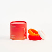 Red container with a white cap and orange cock rings on a white background
