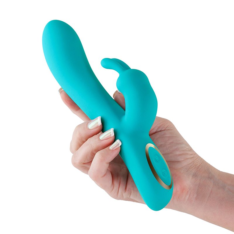 Turquoise silicone vibrator held in a hand against a white background