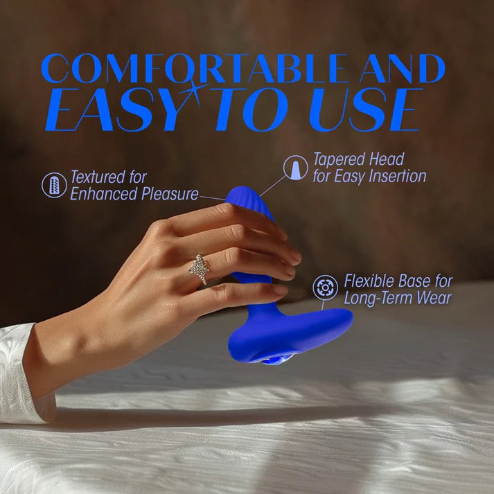 blue vibrating butt plug with rounded head, bottom base, blue gem on bottom, with hand holding the anal plug