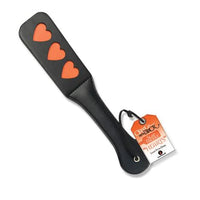 a black paddle with three orange hearts on the end