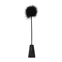 a black riding crop with a feathered end