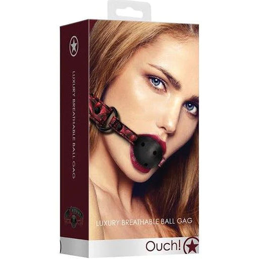 a burgundy box depicting a woman wearing a black ball gag with air holes and burgundy straps