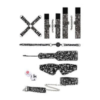 a black and white graffiti patterned bondage kit that includes a hogtie, cuffs, a ball gag, a paddle, a blind fold, a collar and a chain leash